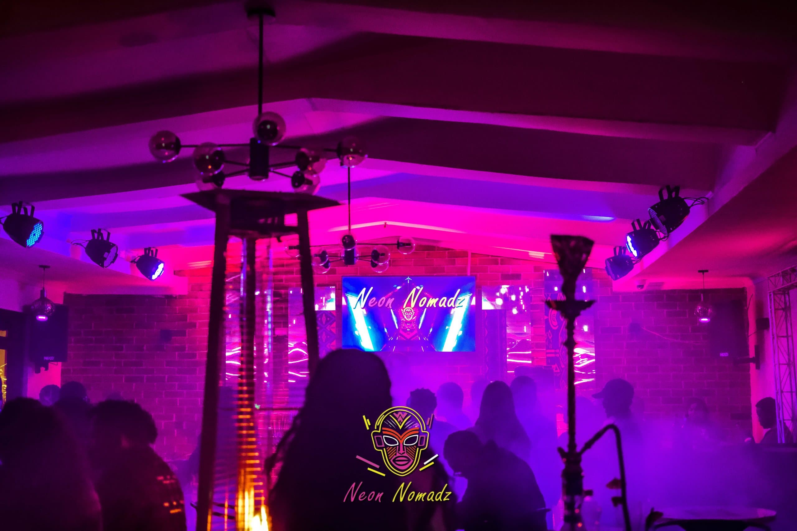 Neon Nomadz crowd and stage beneath magenta light